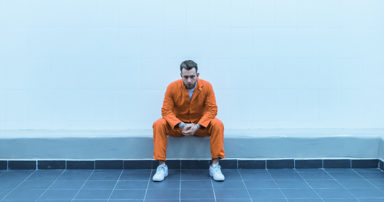 Incarcerated male sitting on bench