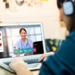 Person looking at computer with doctor on screen