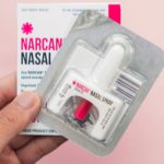 Hand holding a nasal narcan kit