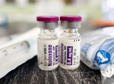 two vials of injectable naloxone on a wooden table