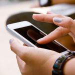 Hands holding and tapping on a mobile phone