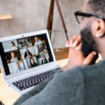 Man looking at Zoom session on laptop