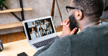 Man looking at Zoom session on laptop